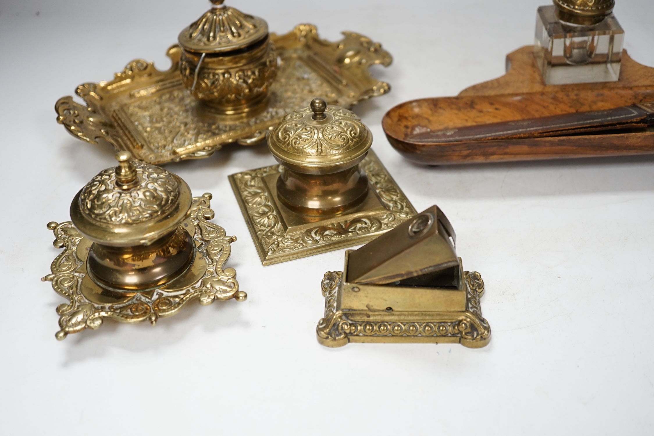 Sundry items to include brass desk stand, inkwells, letter openers and a cigar cutter, largest 26cm wide. Condition - fair